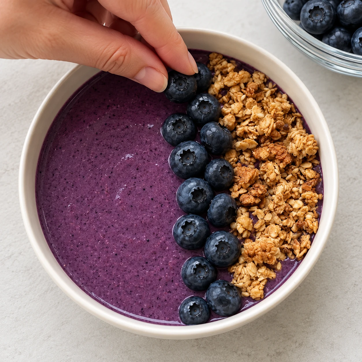 Les myrtilles fraîches forment une bande distincte à côté du granola.