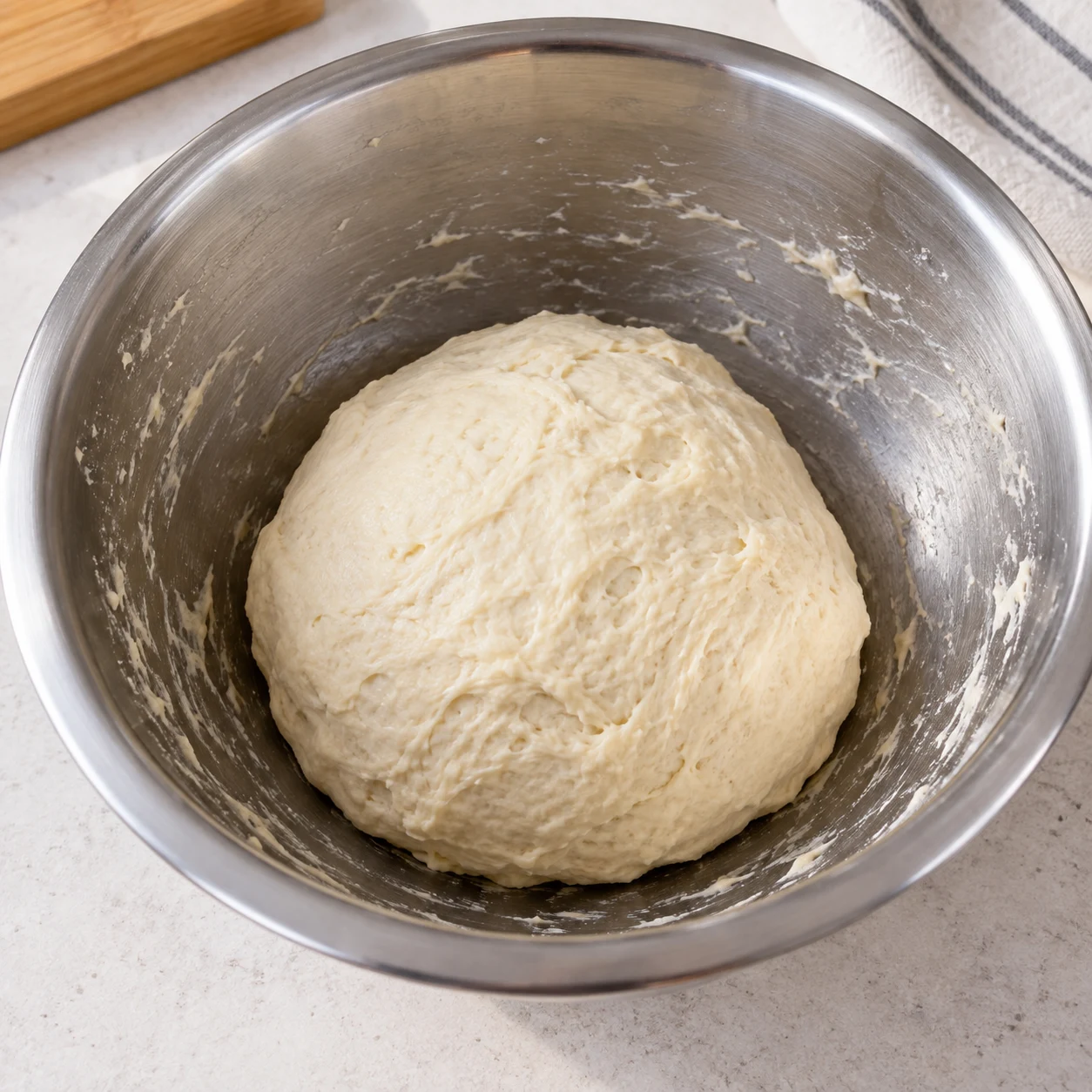 Former la pâte. La pâte est rassemblée et aucune farine sèche ne reste dans le saladier.
