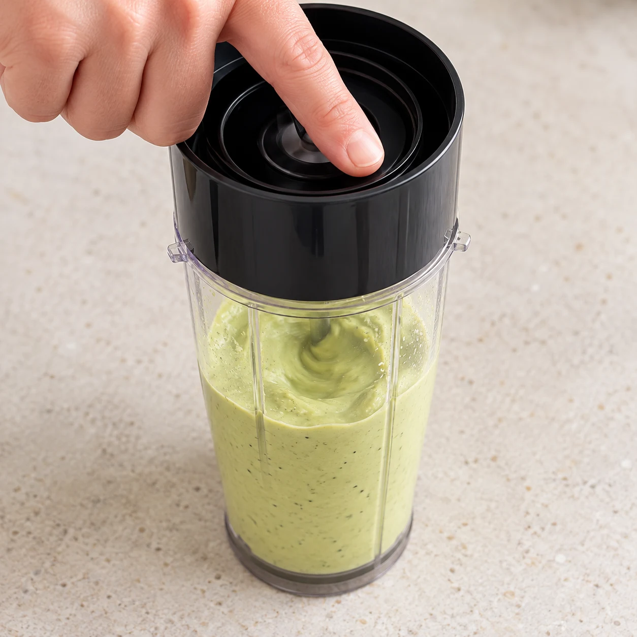 Blender fermé contenant les ingrédients de la sauce en cours de mixage, mains anonymes ; geste décrit dans la recette d’origine, capture montrant l’état des ingrédients juste avant mixage.