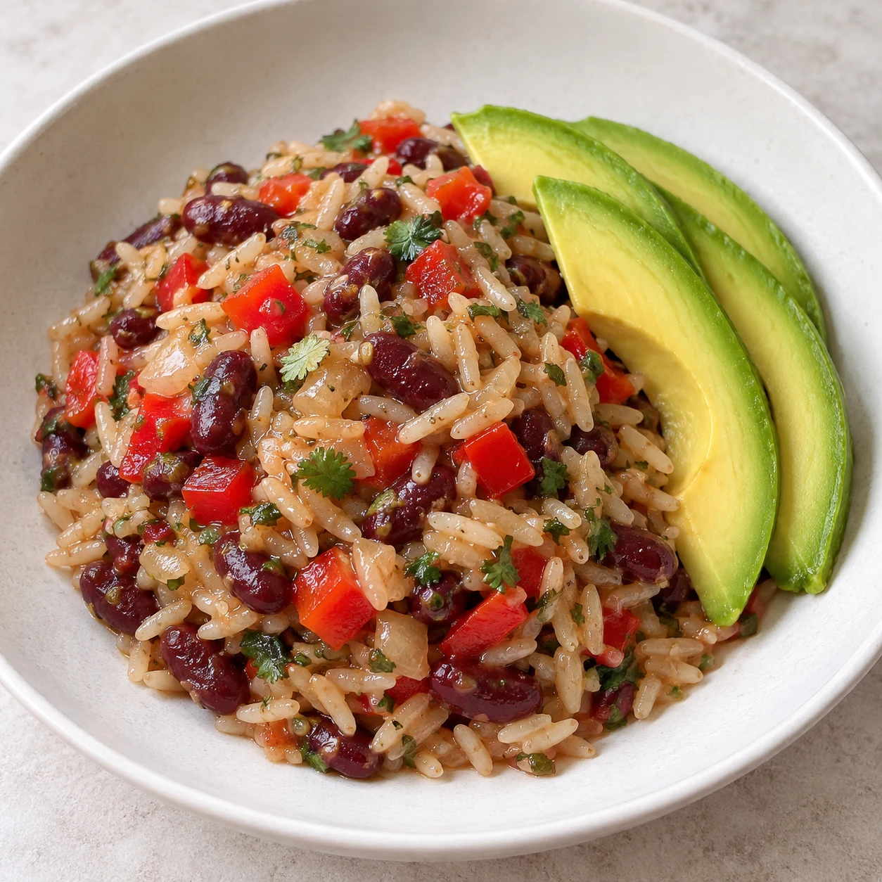 Plat fini de riz basmati aux haricots rouges, morceaux de poivron rouge, oignon et herbes, sauce brillante, quelques tranches d’avocat. Aucun œuf.