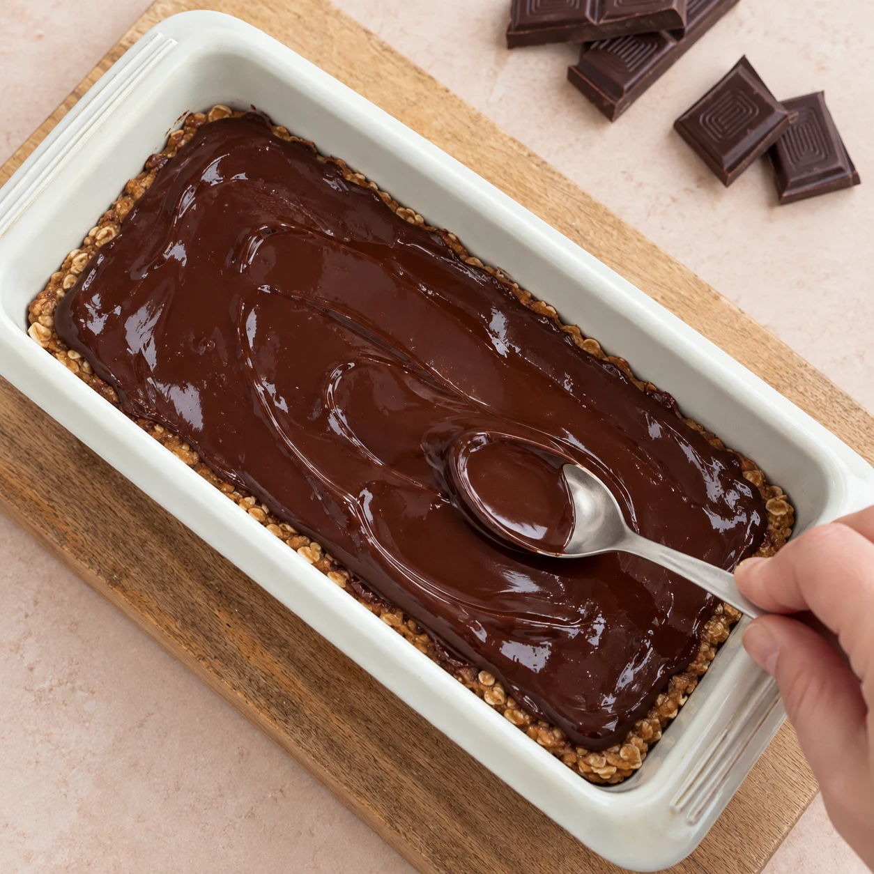 Verse le chocolat fondu sur la base refroidie et étale-le avec le dos d’une cuillère. État à montrer : Le chocolat couvre la surface de la base.