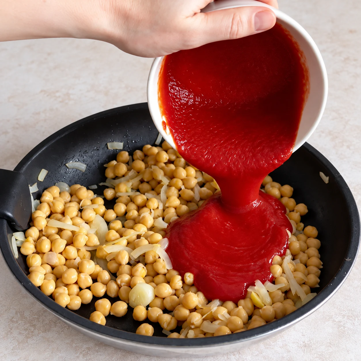 Ajoutez les 20 cl de purée de tomates et la cuillère à café de concentré de tomates. Une seule scène et une seule phase ; ne montrer que les ingrédients autorisés à cette étape.
