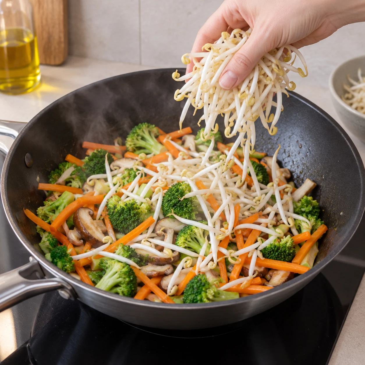 Des pousses de mungo fraîches sont ajoutées dans le wok.