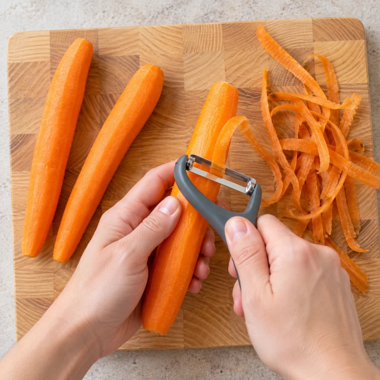 Éplucher les carottes : Les carottes sont débarrassées de leur peau.