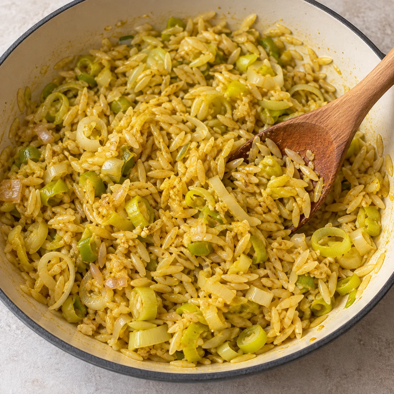 Nacrer l’orzo. L’orzo est réparti dans les légumes et enrobé de matière grasse.. Reproduire une seule action, ingrédients exacts et phase exacte. Adapter les crevettes visibles en pois chiches cuits entiers uniquement après son ajout. Aucun ingrédient futur.
