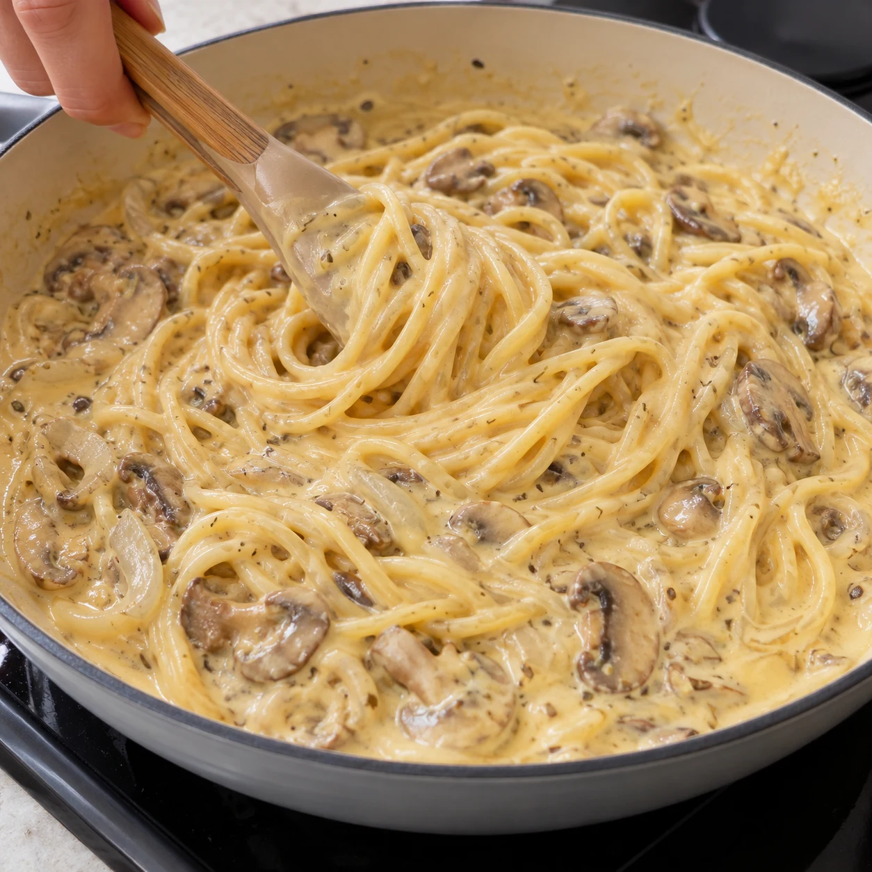 Incorporez les 30 g de tranchettes végétales découpées aux pâtes chaudes et mélangez jusqu’à ce qu’elles fondent dans la sauce. La finition fondante est jaune pâle ; pas de parmesan ni de fromage râpé.