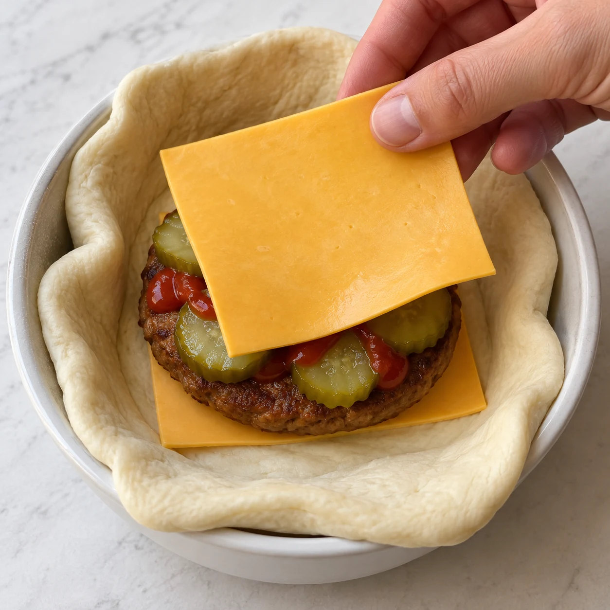 Mains adultes anonymes posant le fromage végétal restant au-dessus de la garniture du pocket, avant la fermeture.