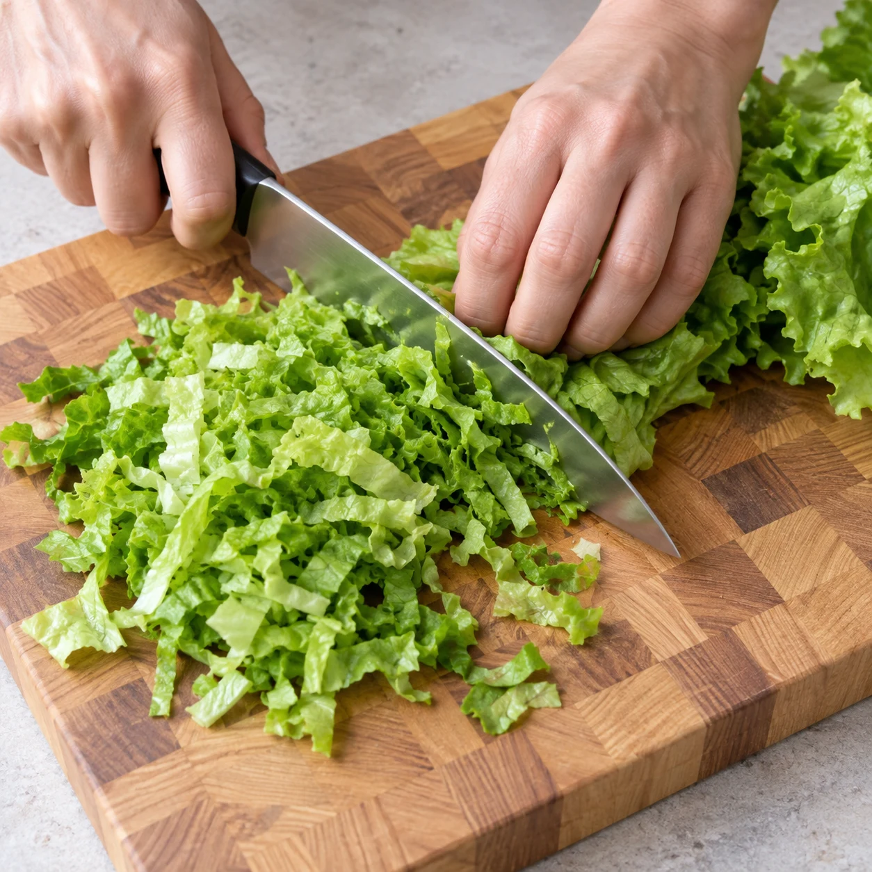 Feuilles de salade verte émincées sur une planche.