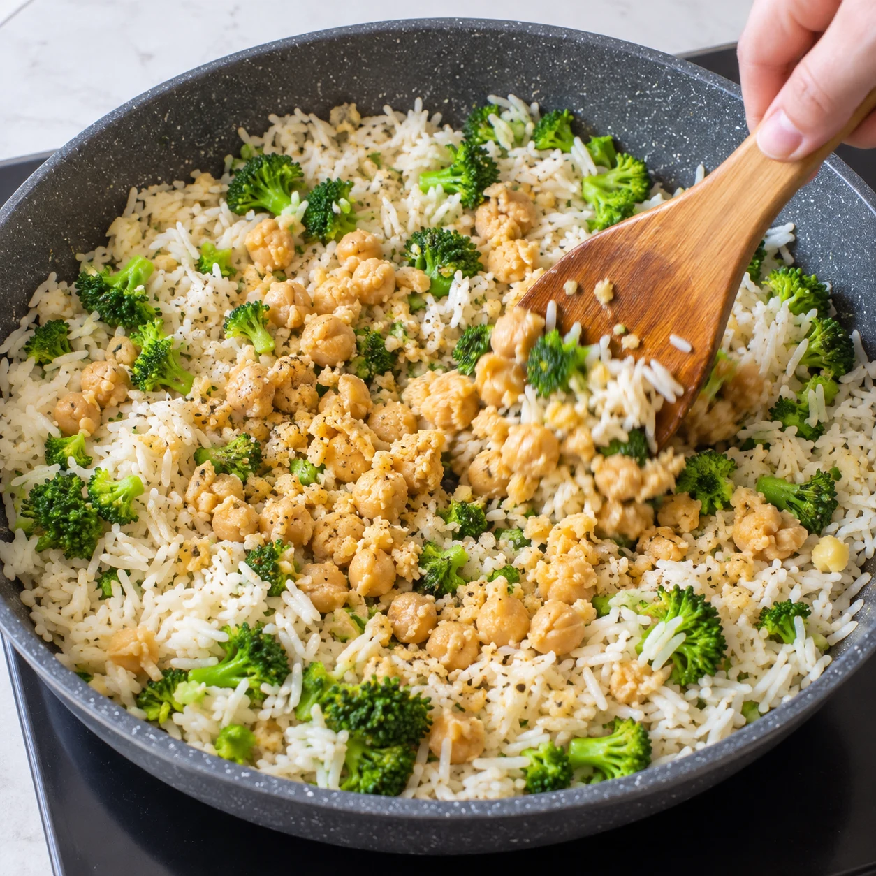 Morceaux de pois chiches écrasés au centre du riz et du brocoli sauté ; miettes beige clair, aucun œuf.