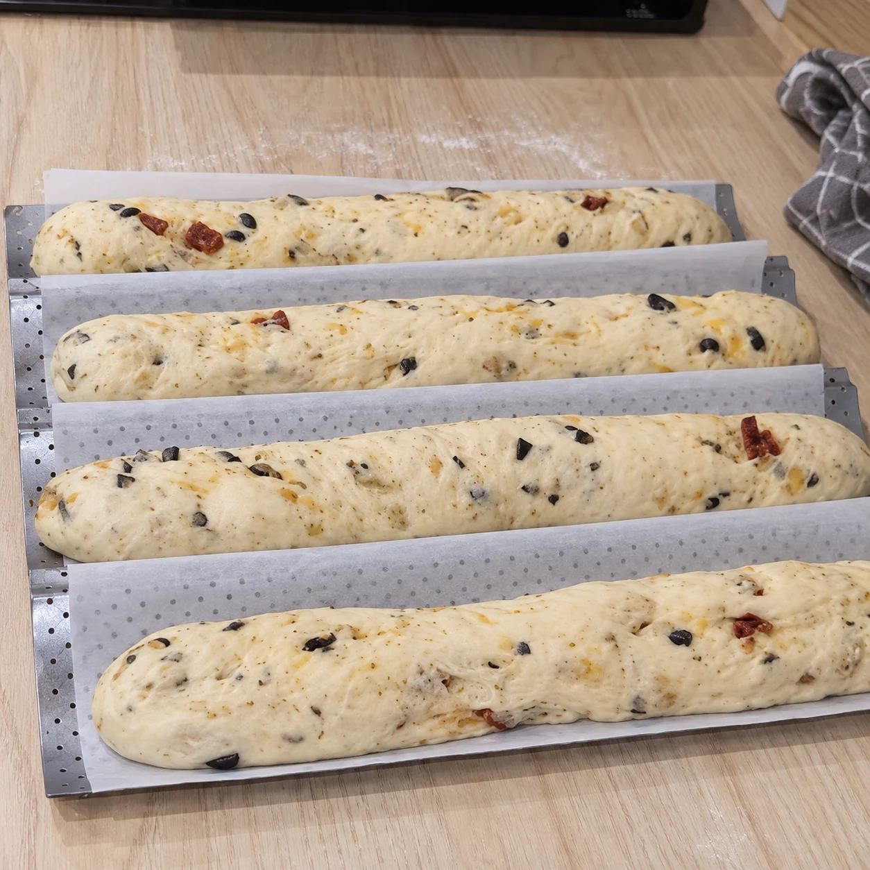 Laisser lever sur la plaque. Les baguettes ont gonflé tout en gardant leur forme. Respecter la capture source ; chorizo et cheddar uniquement végétaux, aucune autre garniture.