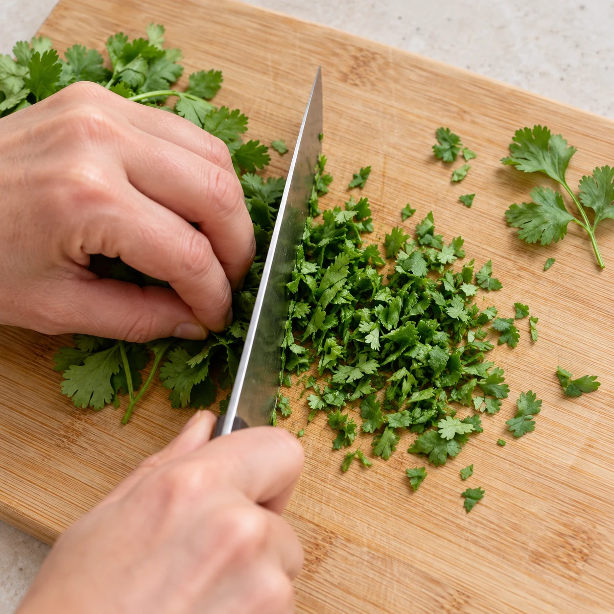 Hacher quelques feuilles de coriandre avec une prise en griffe sûre.