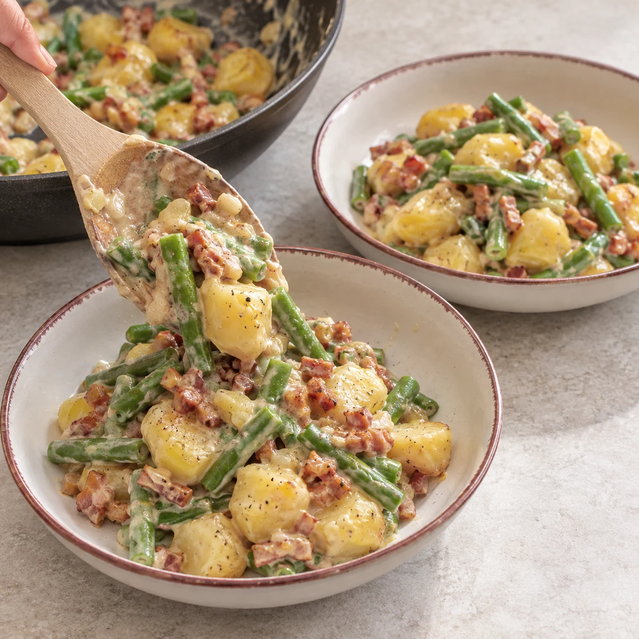 Servir : Répartissez la poêlée chaude dans deux assiettes. Résultat : Les deux assiettes contiennent des légumes, des lardons végétaux et de la sauce.