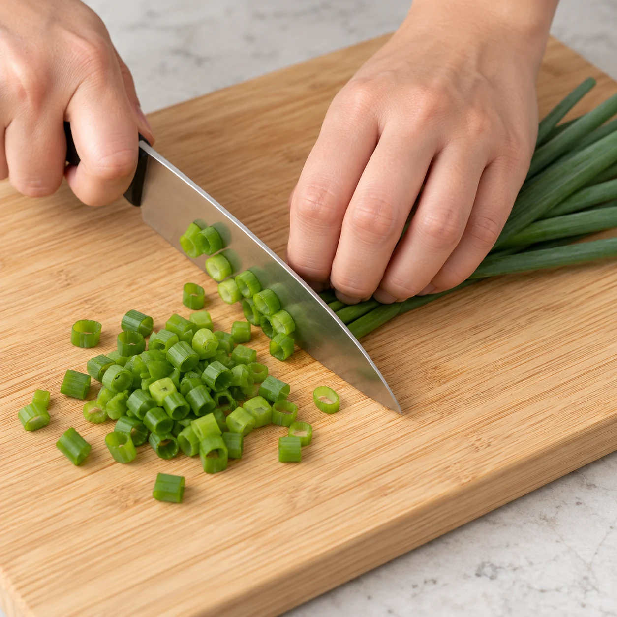 Émincer le vert de cébette : Émince le vert de cébette destiné à décorer les boulettes.