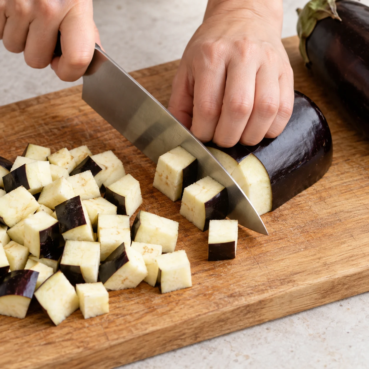 Tailler l’aubergine du confit : L’aubergine est coupée en petits cubes grossiers.