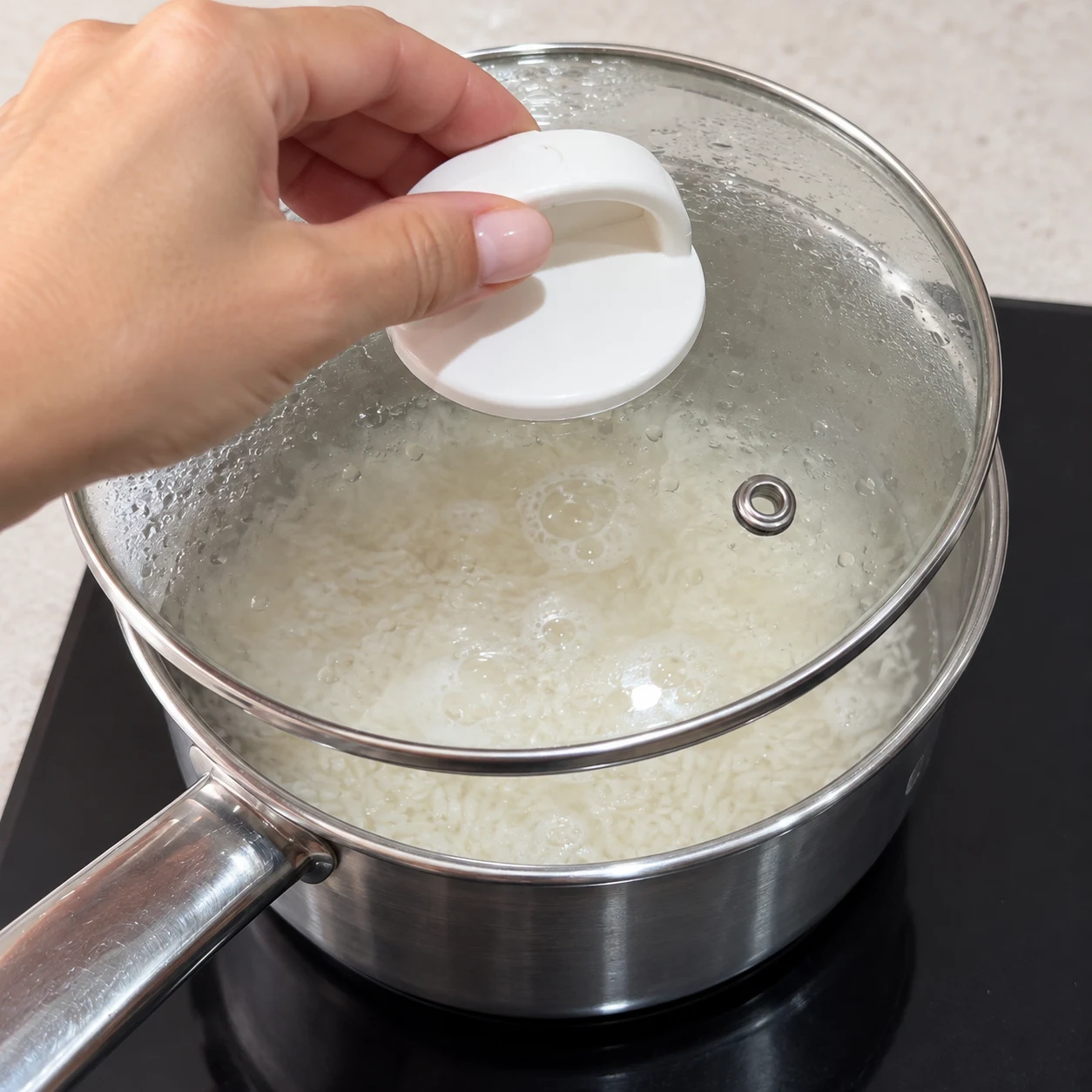 Main anonyme posant le couvercle sur la casserole de riz.