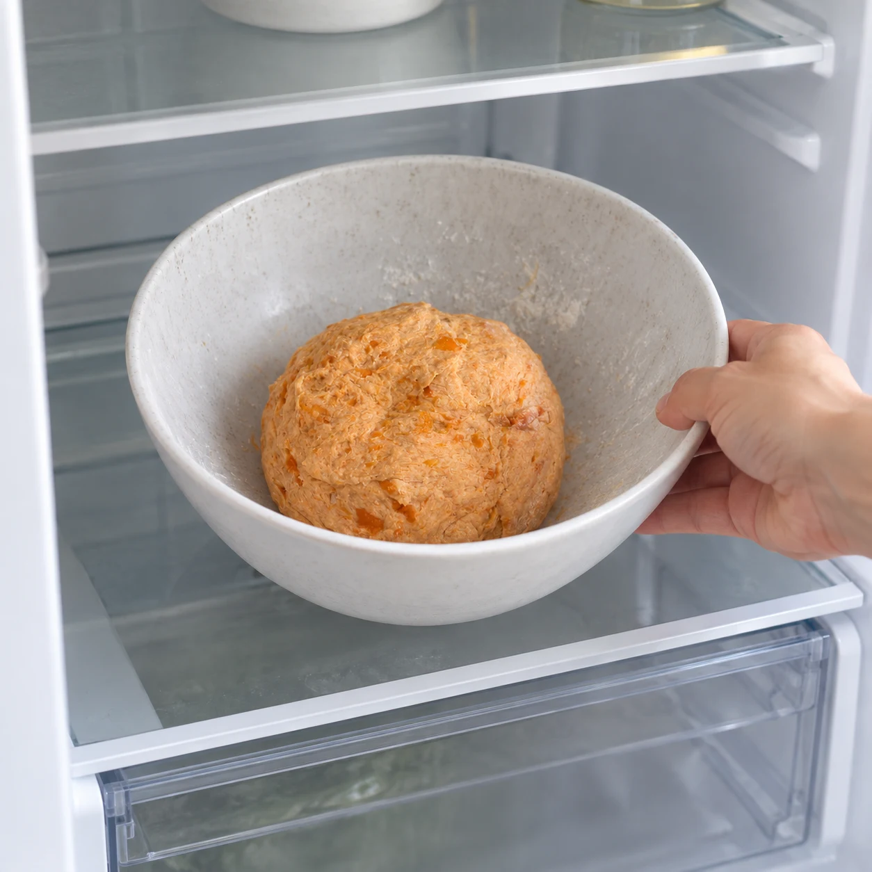 Bol contenant une boule orange au réfrigérateur, aucune garniture.