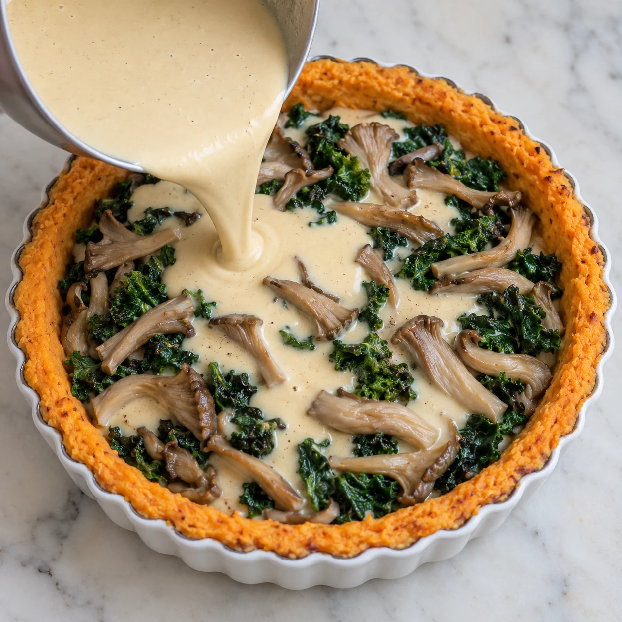 Appareil végétal beige clair lisse versé sur kale et pleurotes dans base orange ; pas de fromage ni œufs.