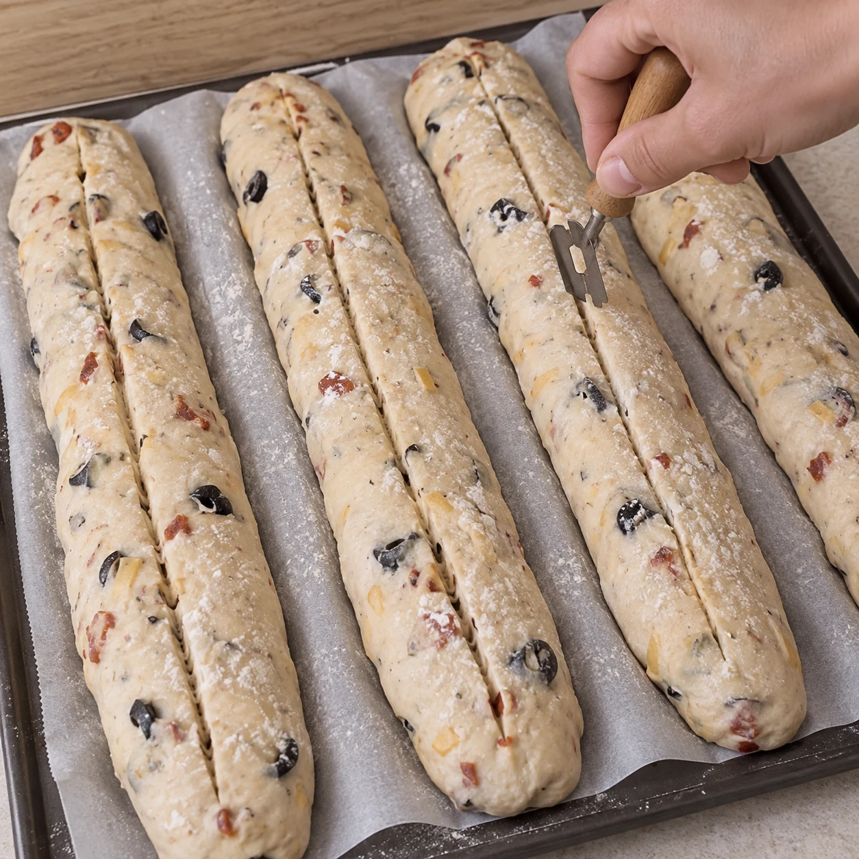 Scarifier les baguettes. Une entaille longitudinale est visible sur chaque baguette. Respecter la capture source ; chorizo et cheddar uniquement végétaux, aucune autre garniture.