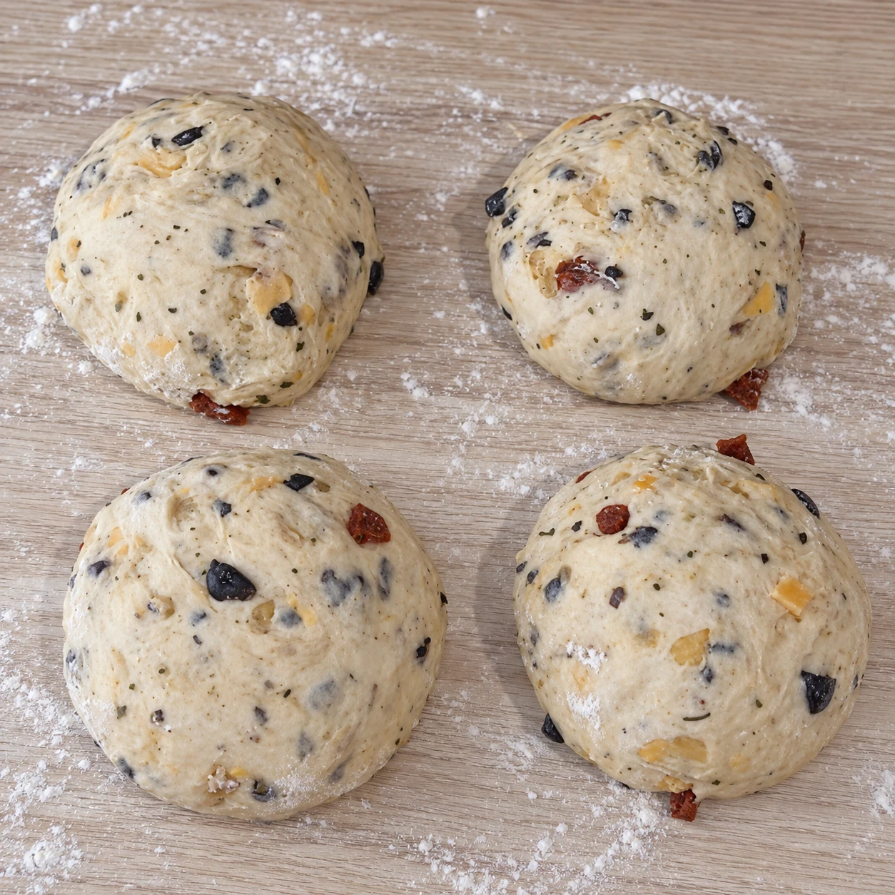Diviser en quatre boules. Quatre boules distinctes de taille comparable sont prêtes. Respecter la capture source ; chorizo et cheddar uniquement végétaux, aucune autre garniture.