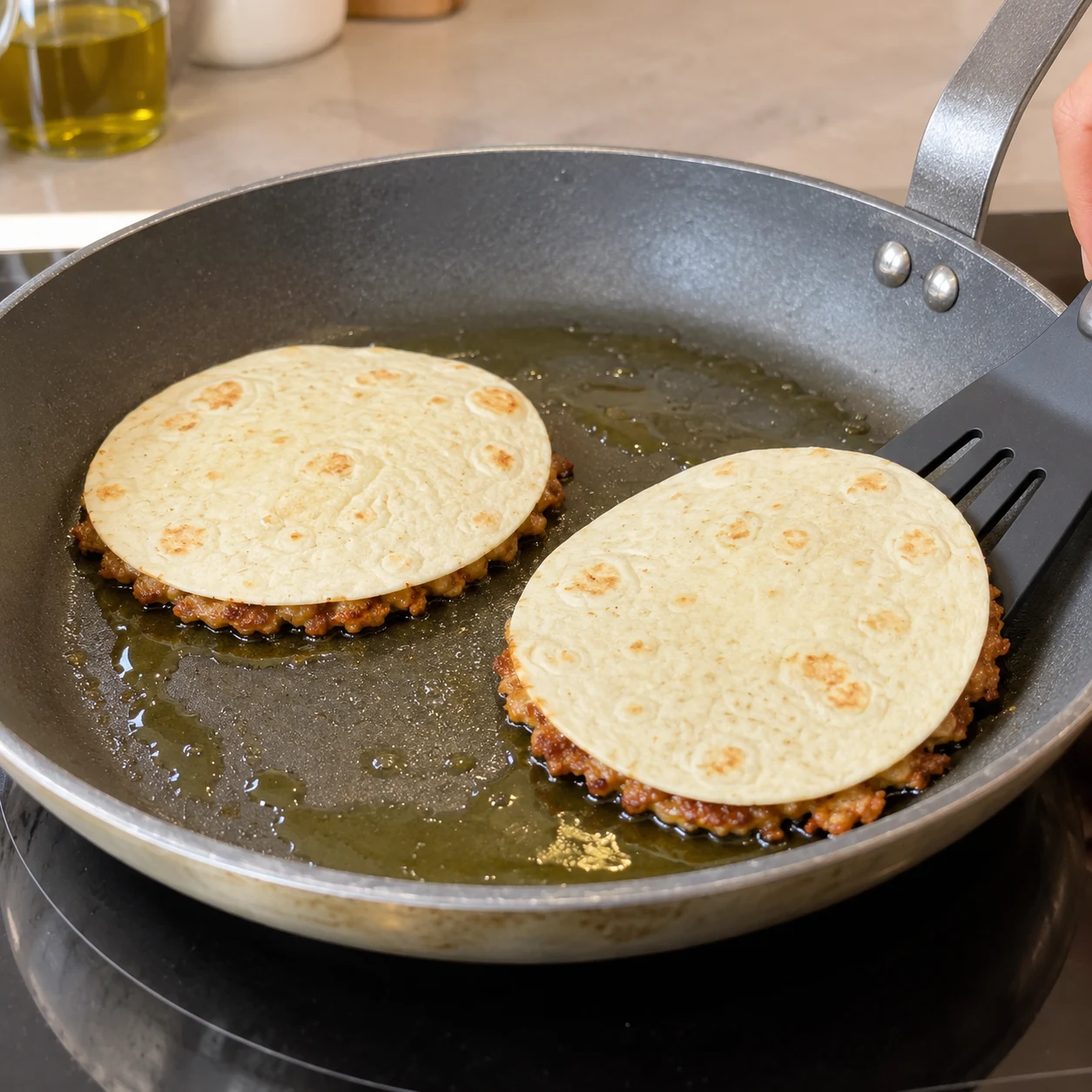 Petites tortillas face nue vers le haut dans une poêle huilée.