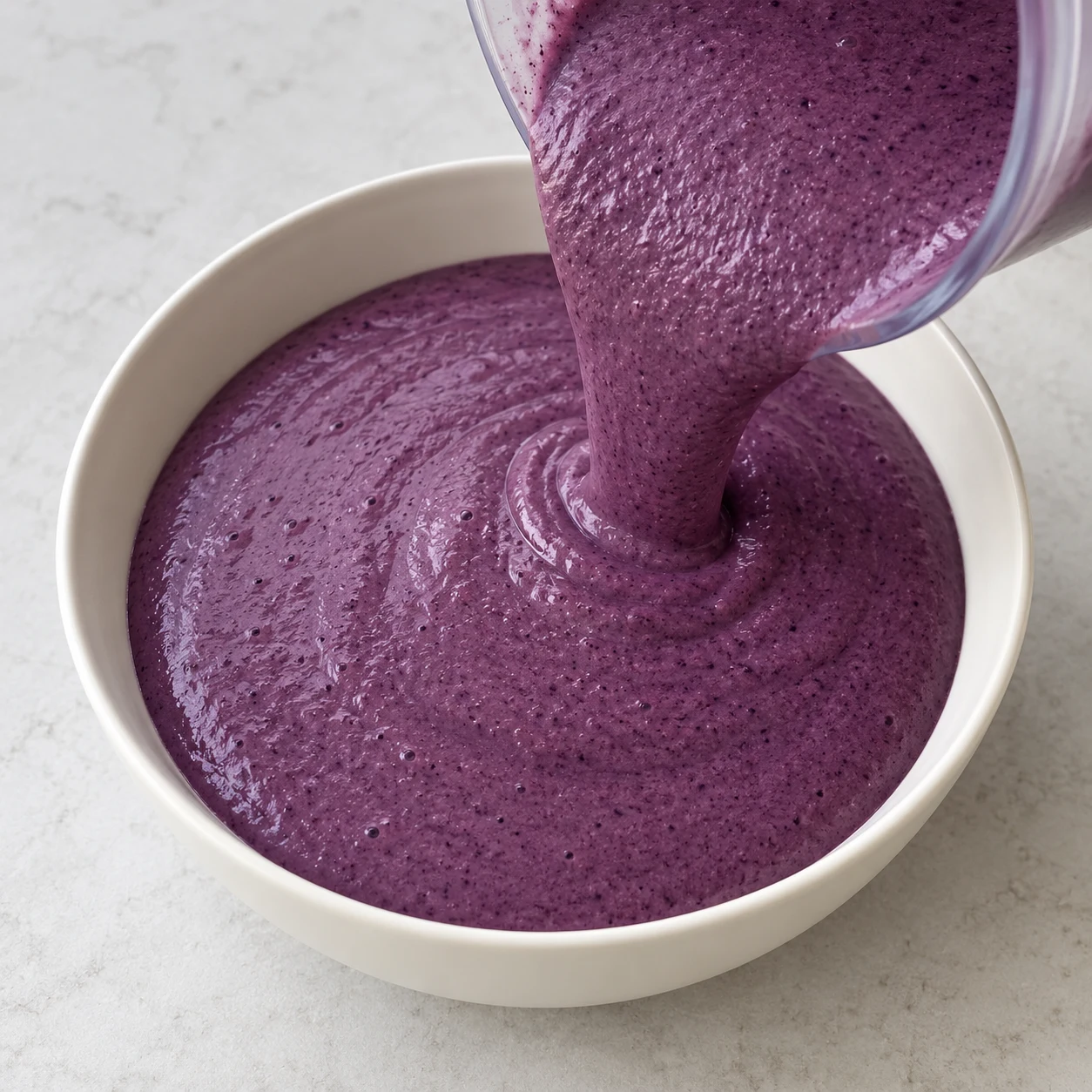 La crème violette forme une surface continue dans le bol.