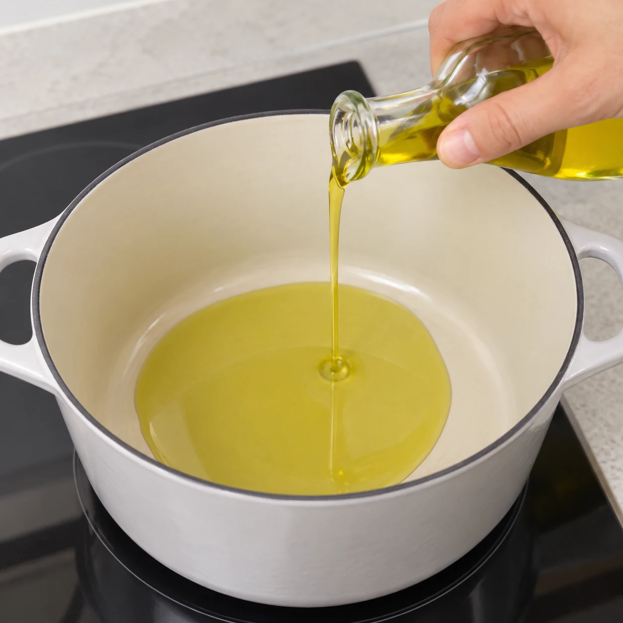 Un filet d’huile d’olive versé dans une cocotte vide.