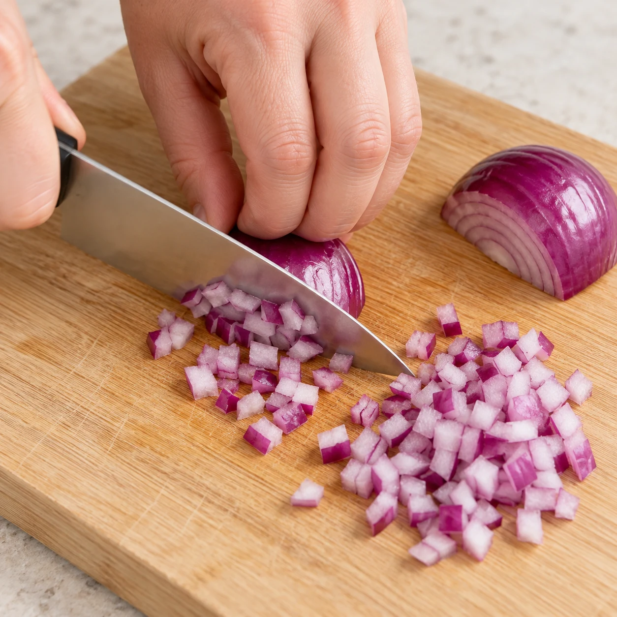 Coupe les 15 g d’oignon rouge en petits dés sur une planche stable, les doigts repliés. Montrer seulement les ingrédients de cette étape ; adaptation végétale, aucun saumon ni produit laitier.