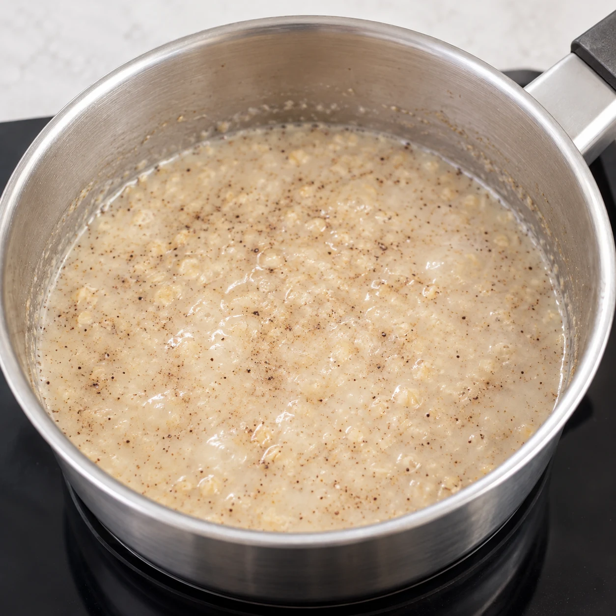 Vanille en poudre brun foncé et sucre roux ajoutés au porridge liquide.