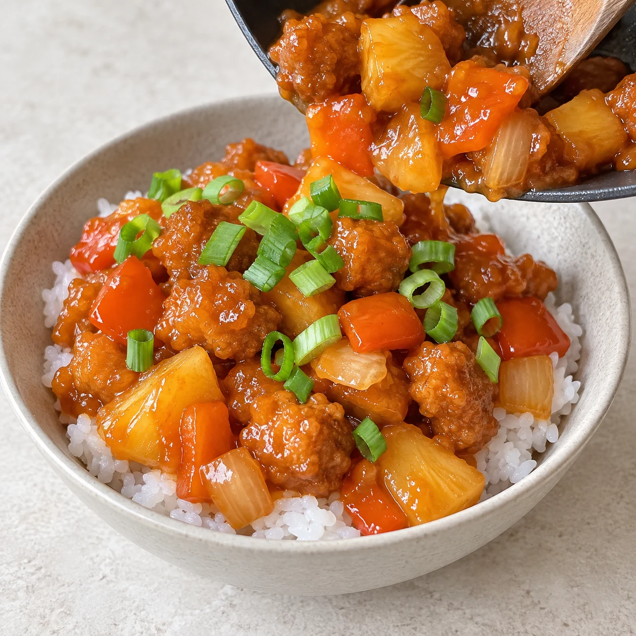 Servir le tofu à l’ananas sur du riz cuit et parsemer de cébette ciselée. La source ne dose pas ces accompagnements. Le résultat à reconnaître : La sauce et les bouchées recouvrent le riz ; la cébette est répartie dessus.