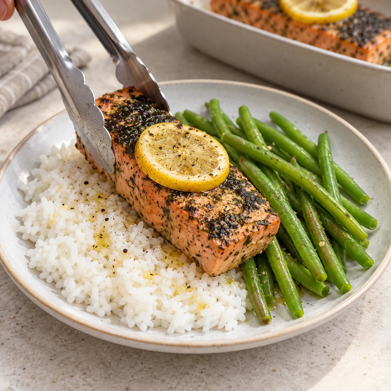 Le filet rosé avec sa peau sombre et sa rondelle de citron accompagne le riz blanc et les haricots verts.