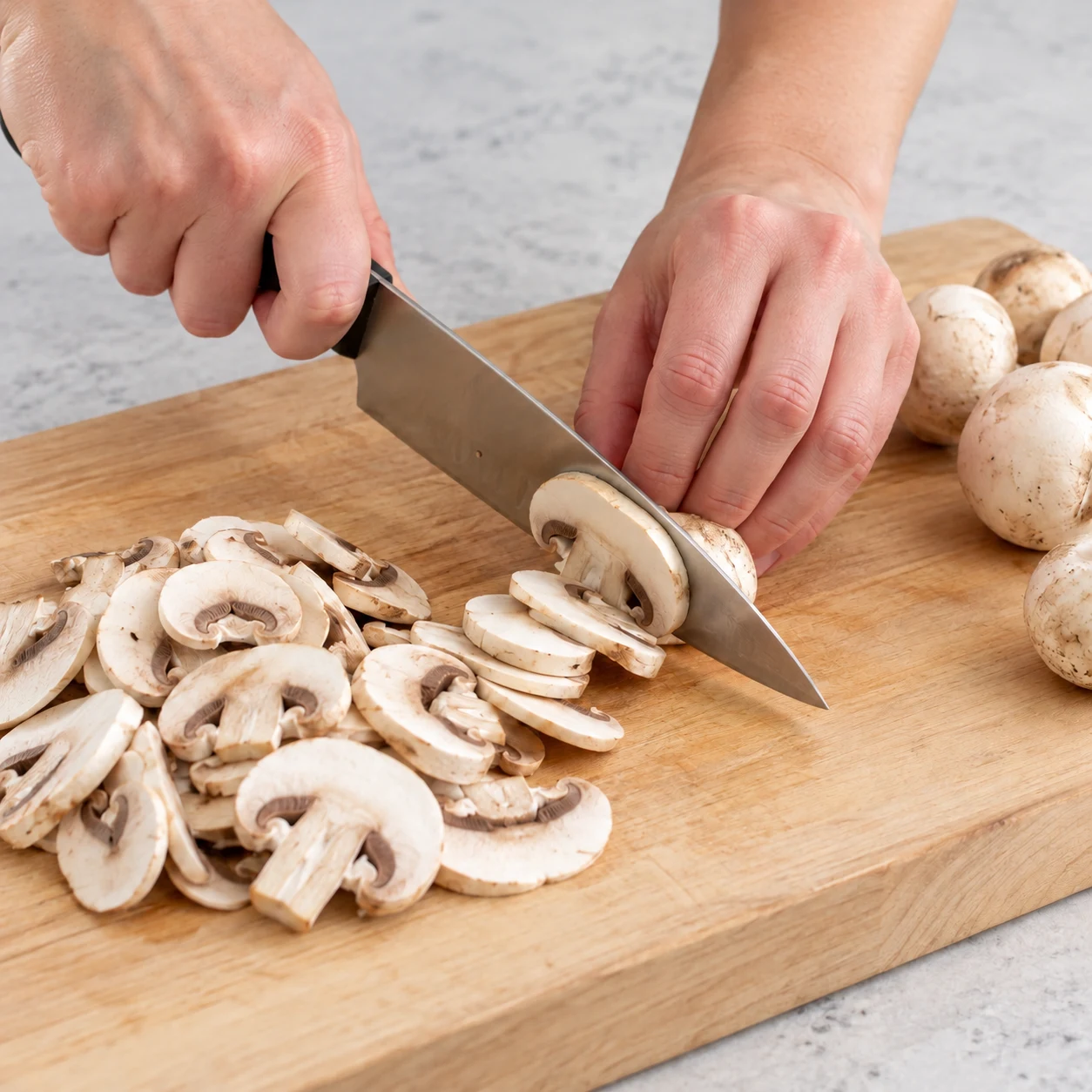 Une seule action : Émincer les champignons. Les champignons forment des lamelles régulières. Uniquement les ingrédients de cette phase : Champignons de Paris.