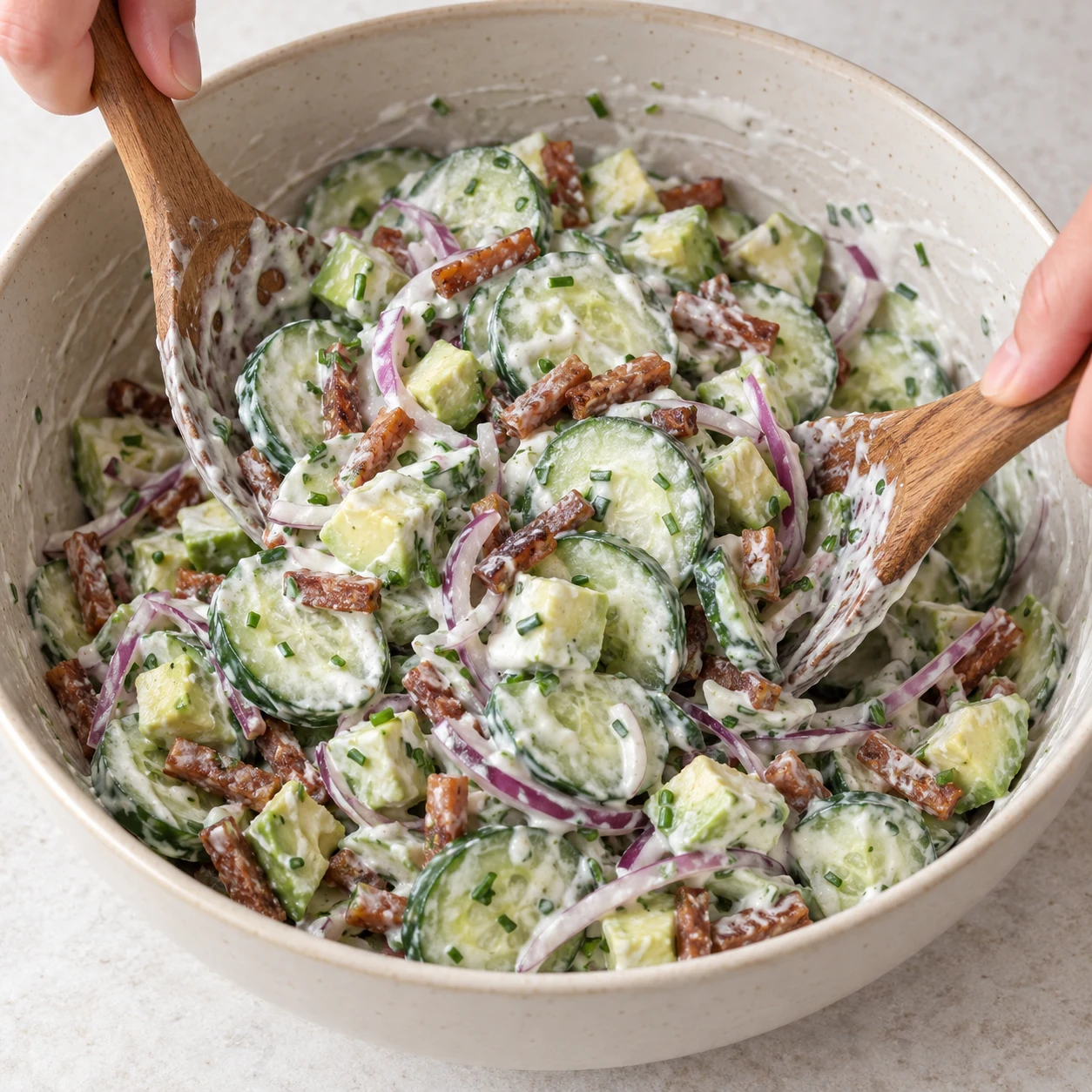 Salade froide de rondelles de concombre, dés d’avocat, fines lamelles d’oignon rouge et allumettes végétales poêlées, enrobée de sauce blanche au yaourt.