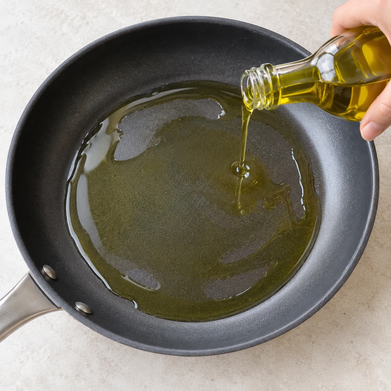 Verse un filet d’huile d’olive dans une grande poêle. Une fine couche d’huile couvre le fond.