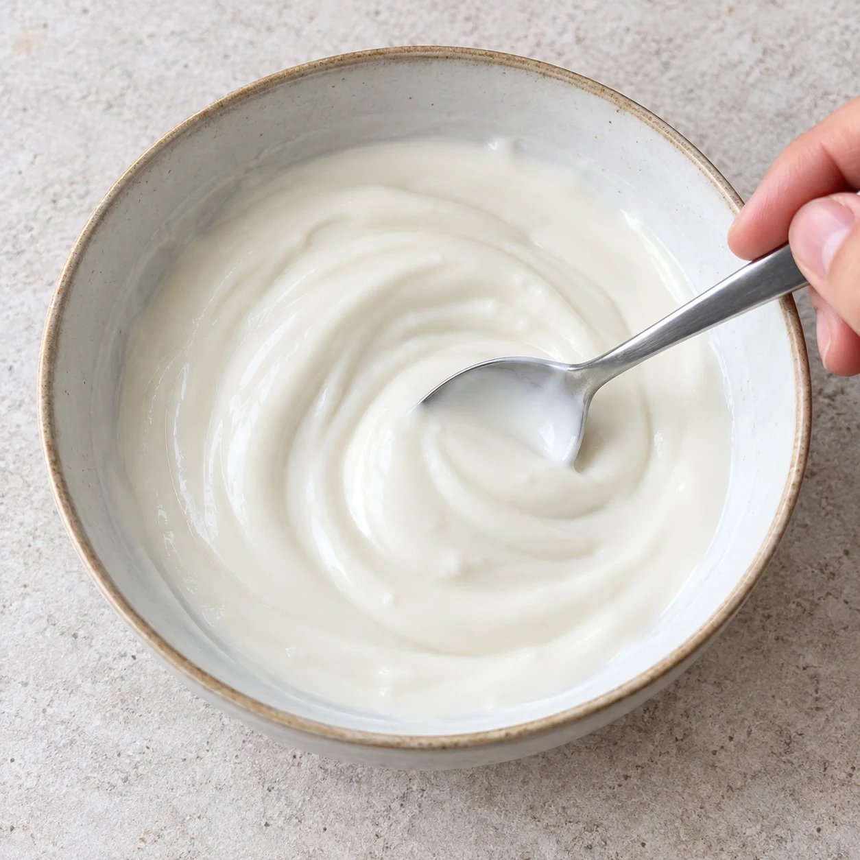 Un bol de soja nature blanc lisse, remué à la cuillère ; aucune pâte ni garniture.