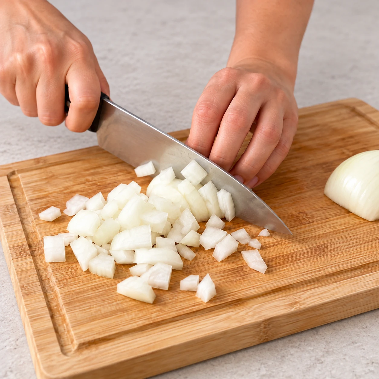 Épluche l’oignon et coupe-le en morceaux comme ceux visibles dans la recette d’origine, sur une planche stable.
