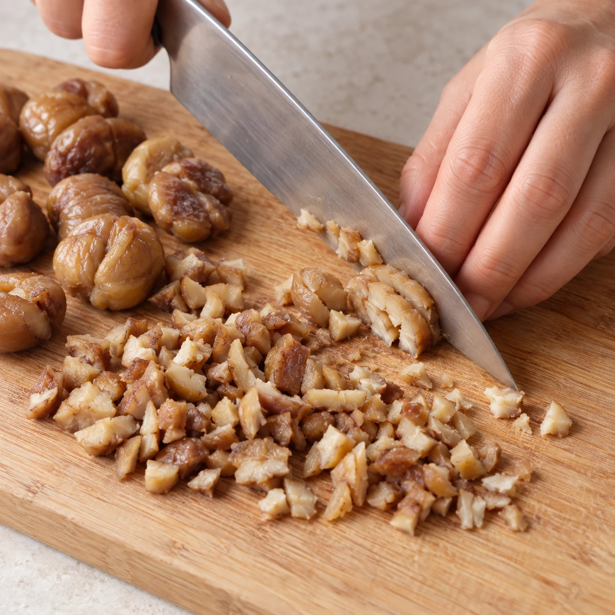 Découpe sécurisée de marrons cuits pelés sur une planche.