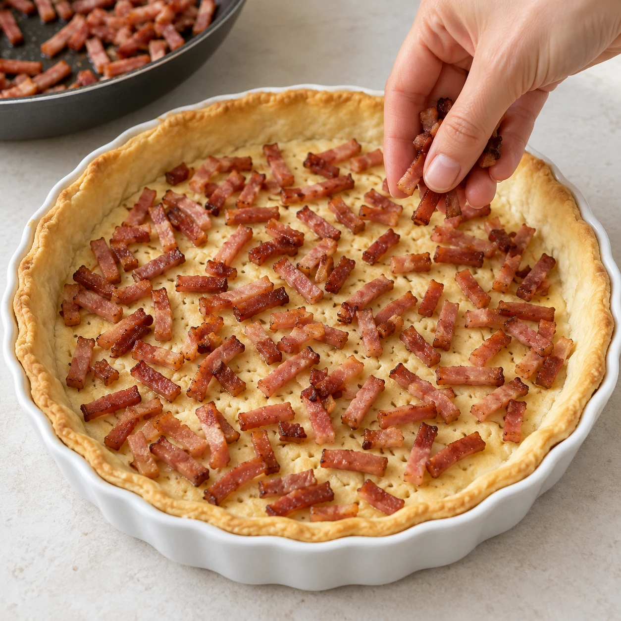 Lardons végétaux rosés dorés répartis sur une pâte brisée précuite.