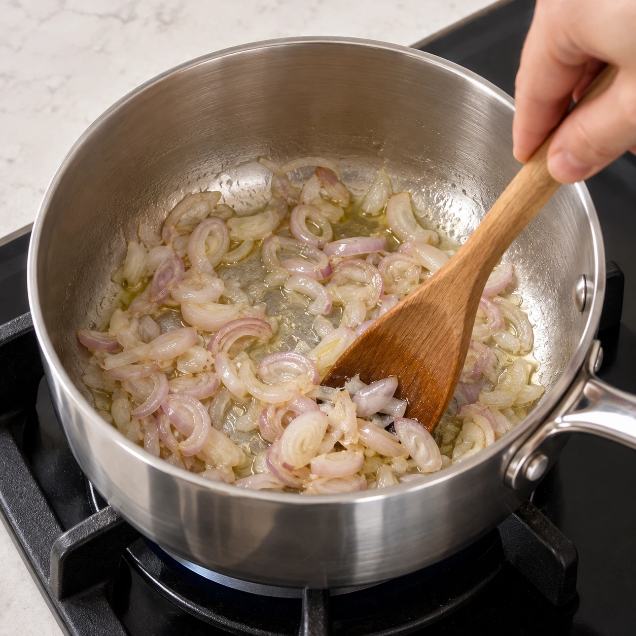 Casserole inox avec échalotes émincées légèrement brillantes, sans pois chiches.