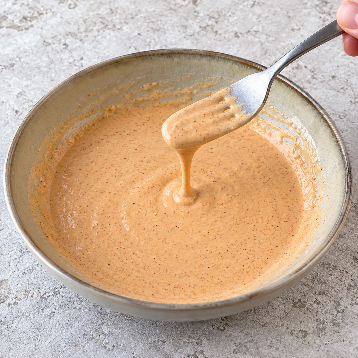 Mélangez les 70 g de farine, la cuillère à café de paprika fumé, la demi-cuillère à café d’ail semoule, la demi-cuillère à café de sel et les 80 ml de boisson végétale dans une assiette creuse. Montrer une seule phase de préparation, sans texte et sans personne identifiable.