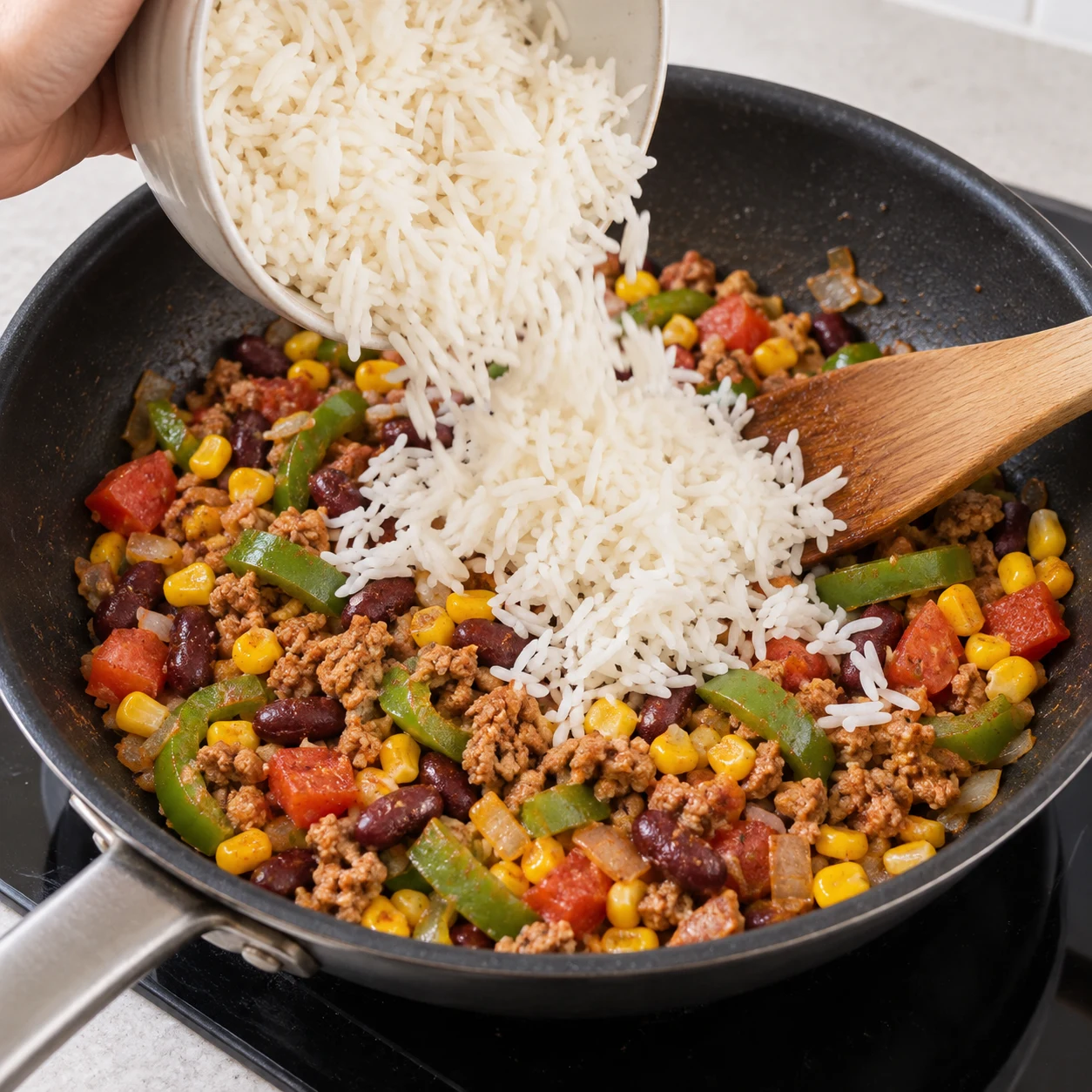 Riz blanc basmati cuit versé dans la poêle ; pas encore de purée de tomate.