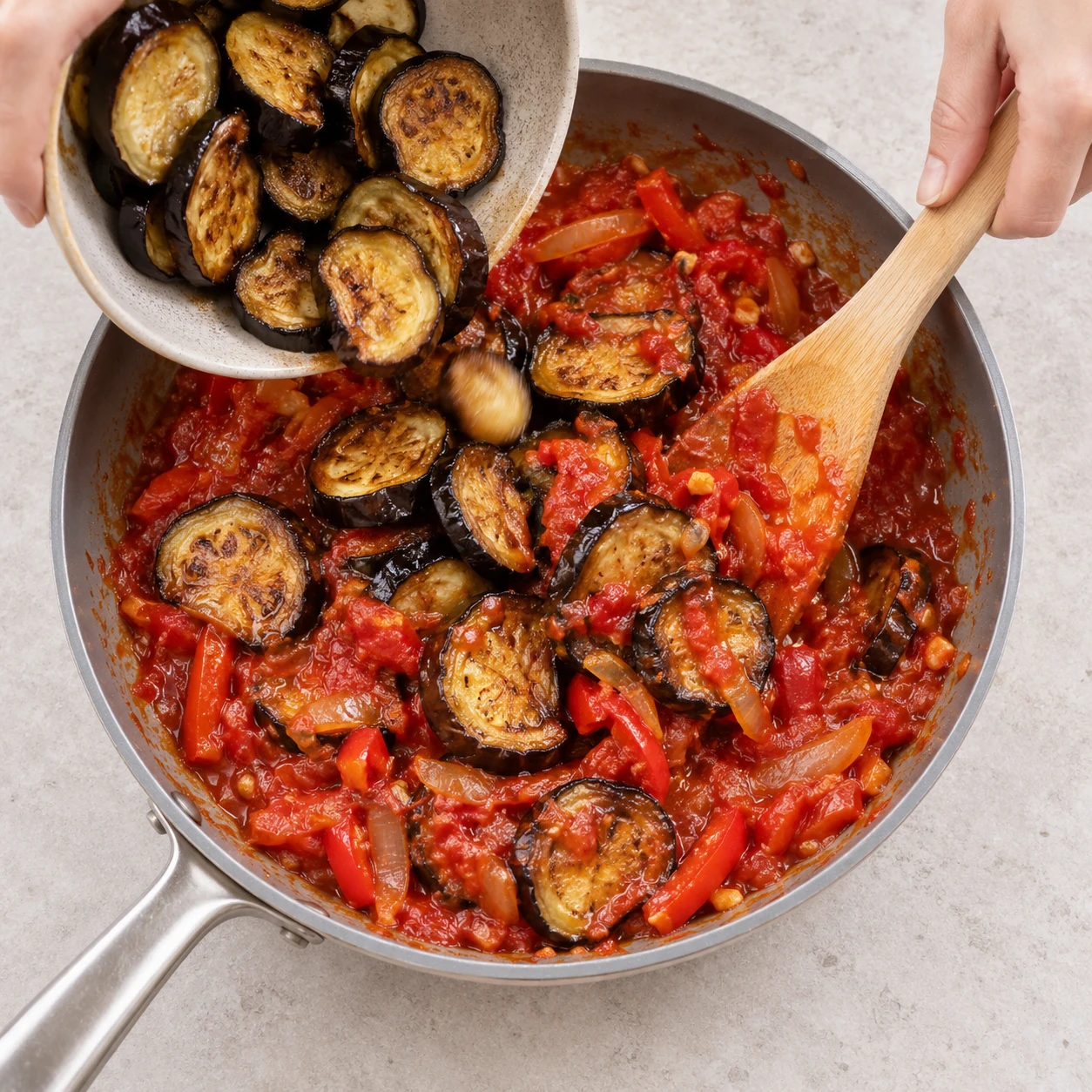 Une seule photo de l’action « Ajouter les aubergines rôties », les rondelles sont enrobées de sauce tomate.