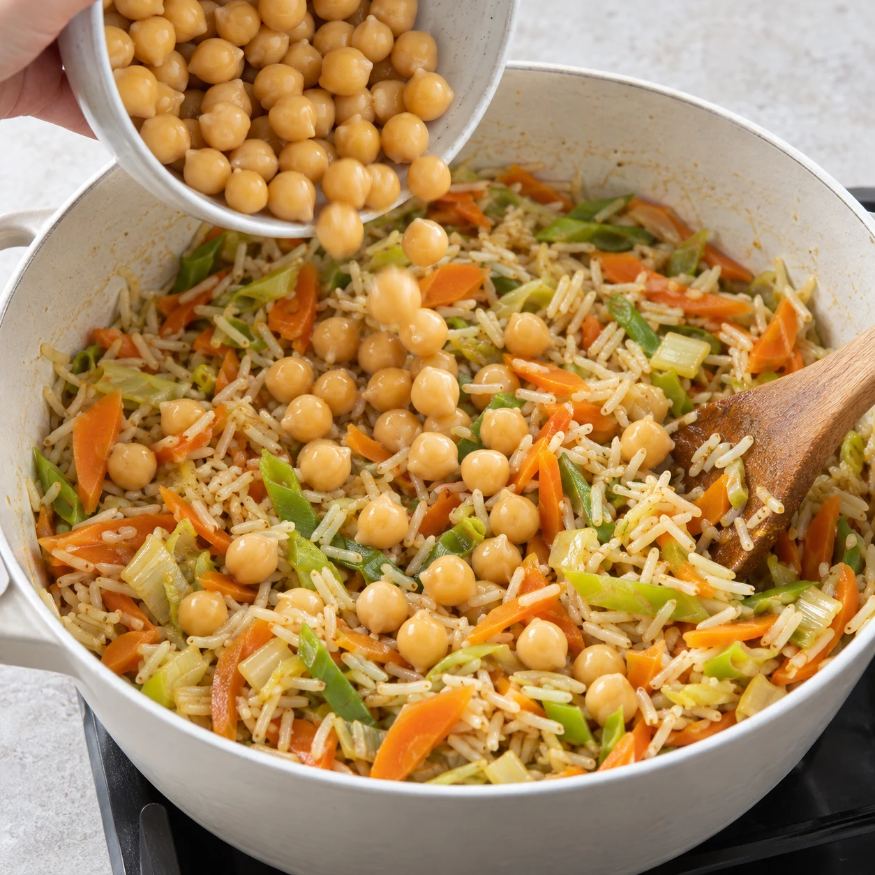 Ajouter les pois chiches. Les pois chiches sont répartis dans le riz.