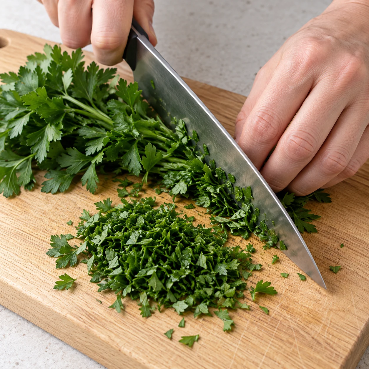 Couper le persil seul sur une planche, couteau tenu sûrement.