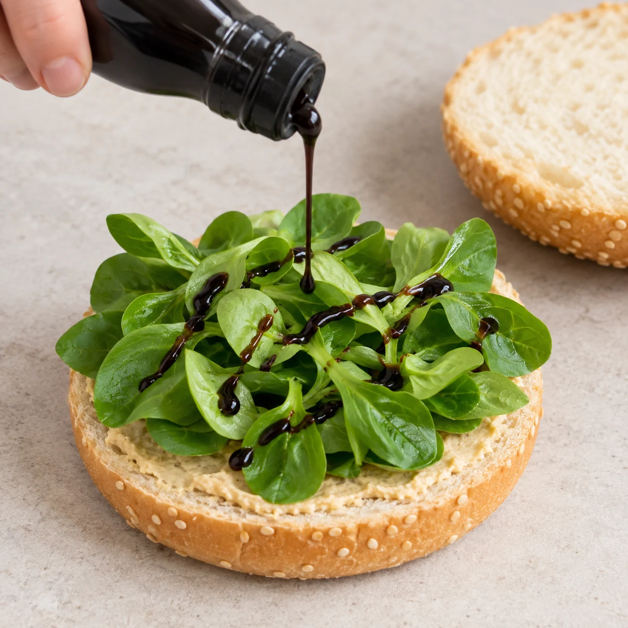 Versez un filet de crème de balsamique sur la mâche. Montrer seulement cette action et les ingrédients déjà présents.