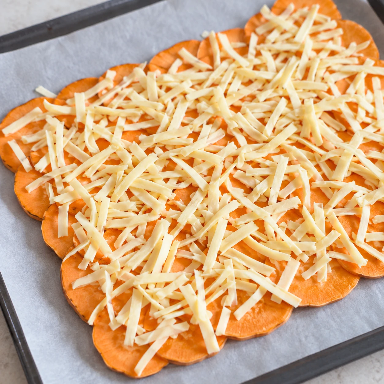 Répartis les lanières végétales sur toute la base de patate douce. Montrer seulement les ingrédients de cette étape ; adaptation végétale, aucun saumon ni produit laitier.
