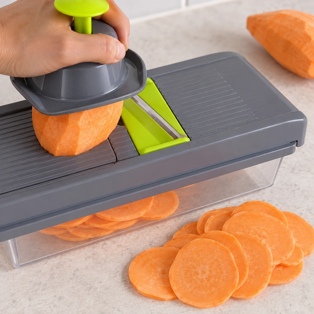 Rondelles fines de patate douce sur mandoline avec poussoir de sécurité.