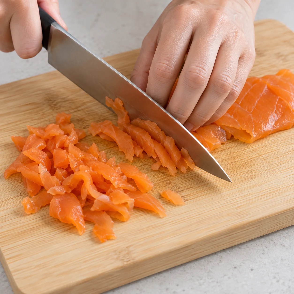 Découpe sûre de fines tranches végétales orange sur une planche stable.