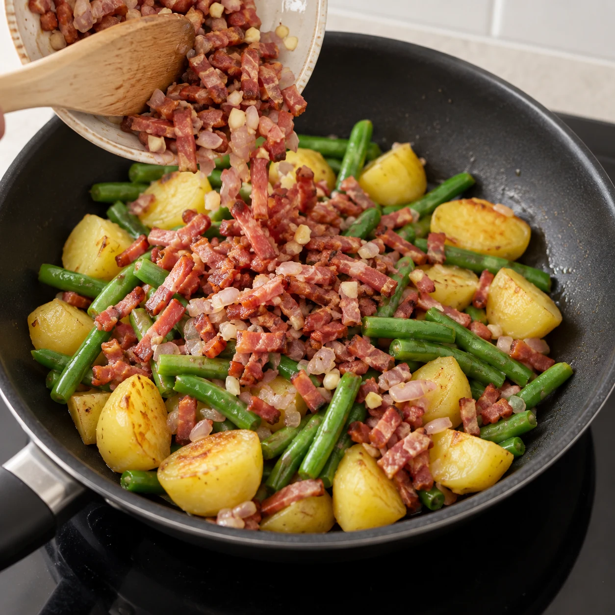 Remettre les lardons et aromates : Remettez le mélange réservé de lardons végétaux, d’échalote et d’ail dans la poêle. Résultat : Le mélange réservé rejoint les légumes dans la poêle.