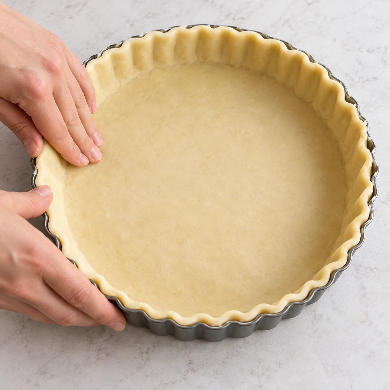 Installer la pâte : La pâte épouse le fond et les bords du moule sans déchirure. Photographie réaliste, ingrédients finaux uniquement, mains anonymes si le geste l'exige.