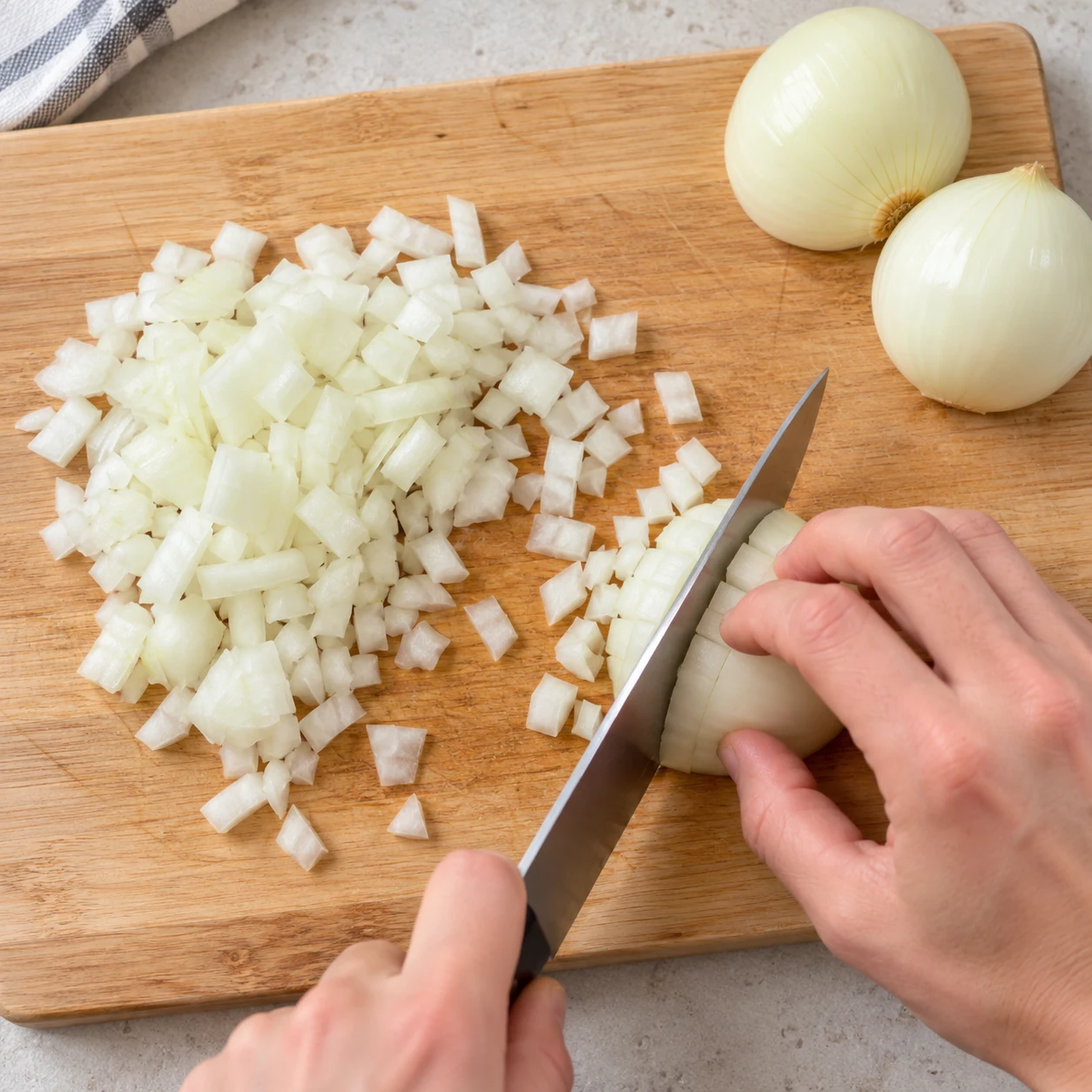 Couper les oignons : Les oignons sont coupés en petits morceaux.